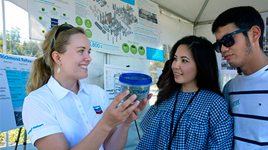 A Chevron volunteer talks to community members at Community Tour Day.