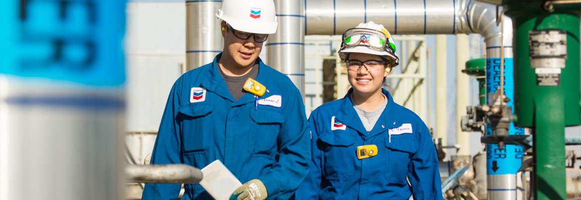 Two process engineers talking while walking outside at Richmond Refinery, Richmond, California.